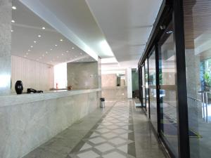 a lobby of a building with a reception counter at 6 Flats Capitania Varan, Pitangueiras, wifi in Guarujá +14 photos