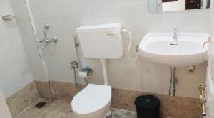 a bathroom with a toilet and a sink at Cinco Filhas in Vasco Da Gama