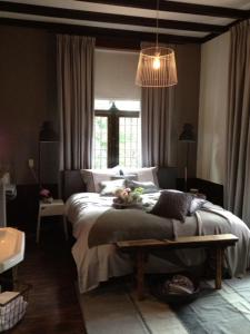 a bedroom with a bed and a pendant light at Hotel Kasteel de Essenburgh in Hierden