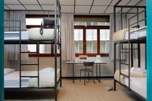 a dorm room with bunk beds and a desk at Plus Florence in Florence