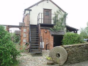 a brick house with a spiral staircase in front of it at Bank Farm Cottages in Nantwich