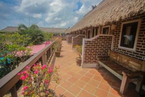 a building with a bench on a patio with flowers at Balangan Sea View Bungalow in Jimbaran