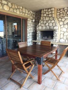 a wooden table and chairs in front of a stone fireplace at Kite View 2 Holiday Home in Witsand