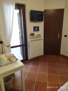 una camera con una porta e un pavimento piastrellato con un tavolo di L'Albicocco a Ladispoli