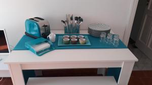 a white table with cupcakes and cups on it at Emidio House in Termini