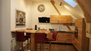 cocina con mesa de madera y sillas rojas en Gasthof/ Pension Renner, en Thalmassing