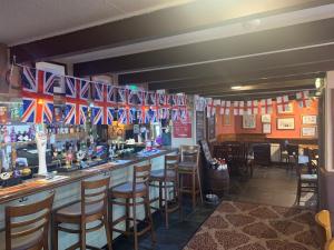 a bar with british flags hanging above it at The Star Inn in Saint Erth