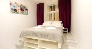 ザグレブにあるSecret studiosの赤いカーテン付きのベッドが備わる小さなベッドルーム1室が備わります。