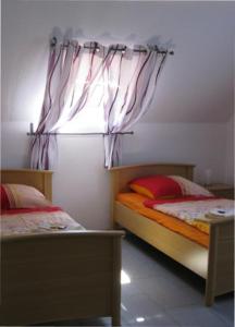 1 dormitorio con 2 camas individuales y ventana en Ferienwohnung Barbara, en Hagenburg