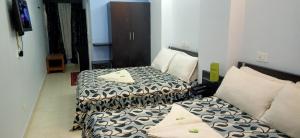 Habitación de hotel con 2 camas y sofá en Hotel Barbareek, en Shillong