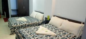 dwa łóżka siedzące obok siebie w pokoju w obiekcie Hotel Barbareek w mieście Shillong