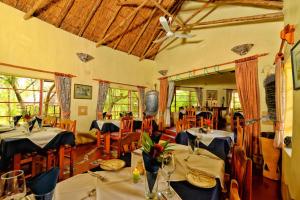 a dining room with tables and chairs in a room at Musangano Lodge in Odzi