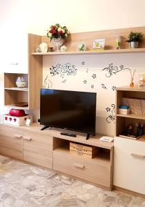 a living room with a television on a wooden entertainment center at la casa al mare in Pescara