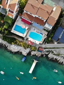 una vista aerea su una piscina nell'acqua accanto alle case di Apartments Villa Marija a Seget Vranjica
