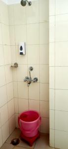czerwone wiadro w łazience z kranem w obiekcie Hotel Barbareek w mieście Shillong