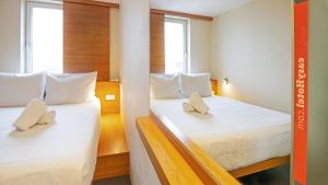 a hotel room with two beds and two lamps at easyHotel Frankfurt City Center in Frankfurt