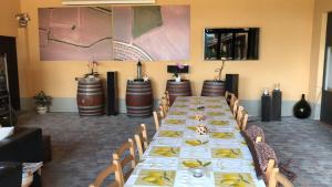 uma longa sala de jantar com uma longa mesa e cadeiras em Villa Vigneto em San Marzano Oliveto