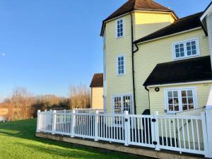 a white fence in front of a house at Hello !! and welcome to Solius Lodge in South Cerney