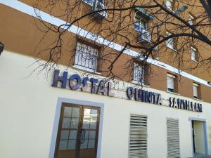un bâtiment avec un panneau sur son côté dans l'établissement Hostal Quinta Santillan, à San Fernando de Henares