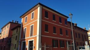 un edificio rojo y blanco en una esquina de la calle en Le case di Chiara, en San Pietro in Casale