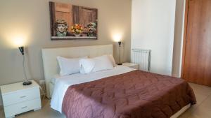 a bedroom with a bed and a painting on the wall at Residence Rapisardi by RECEPTIO in Catania