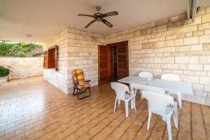 un patio con tavolo e sedie su un pavimento in legno di Casa Vacanze Villa Chiara a San Vito
