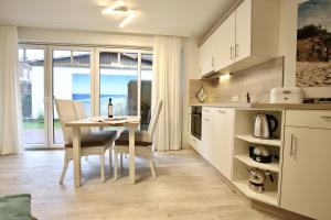 eine Küche mit einem Tisch und einem Esszimmer in der Unterkunft Villa Rossini Wohnung 2 in Wangerooge