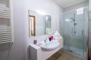 y baño blanco con lavabo y ducha. en Residence Rapisardi by RECEPTIO, en Catania