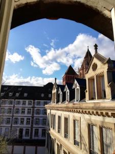 a view through an arch of a building with a church at La Chaumière in Strasbourg