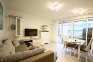 ein Wohnzimmer mit einem Sofa und einem Tisch in der Unterkunft Villa Rossini Wohnung 2 in Wangerooge
