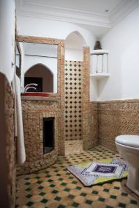 a bathroom with a stone fireplace and a sink at Auberge Tissadrine in Akhendachou nʼAït Ouffi