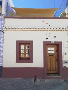a house with two doors and birds on the facade at Casa das Andorinhas in Faro