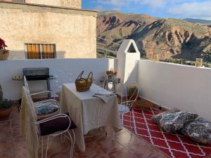a table and chairs on a balcony with a mountain at Casilla Cantón in Canjáyar