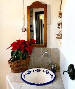 ein Badezimmer mit einem blauen und weißen Waschbecken und einem Spiegel in der Unterkunft Casilla Cantón in Canjáyar
