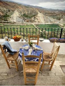 a table and chairs on a balcony with a view at Casilla Cantón in Canjáyar