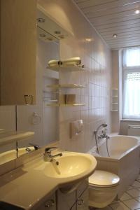 La salle de bains est pourvue d'un lavabo, de toilettes et d'une baignoire. dans l'établissement Pension an der Havel, à Havelberg