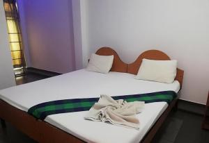 a bedroom with two beds with towels on them at Sunshine Hotel in Trincomalee