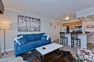 Una sala de estar con un sofá azul y una cocina. en 441-Waterfront, Amazing Views, WIFI, Pool and close to BUCS Stadium, en Tampa