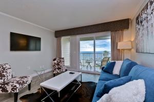 Sala de estar con sofá azul y vistas al océano en 441-Waterfront, Amazing Views, WIFI, Pool and close to BUCS Stadium, en Tampa