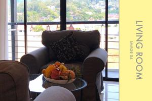a bowl of fruit on a coffee table with a couch at Stylish Condo Stunning Views in Kamala Beach