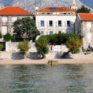 a building on the shore of a body of water at Apartments Lada in Orebić