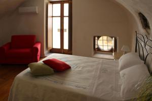 リーパリにあるCasa vacanza U Curtigghiuのベッドルーム1室(大型ベッド1台、赤い椅子付)