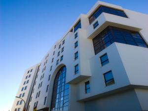 - un bâtiment blanc avec des fenêtres sur le côté dans l'établissement Hotel Apartamento Sinerama, à Sines