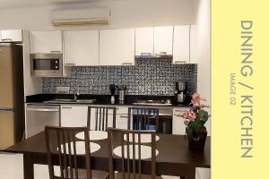 a kitchen with white cabinets and a table and chairs at Stylish Condo Stunning Views in Kamala Beach