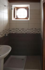 un bagno con lavandino, WC e finestra di Casa vacanza U Curtigghiu a Città di Lipari Altre 24 foto