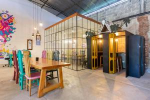 a dining room with a wooden table and colorful chairs at Socialtel Antigua in Antigua Guatemala