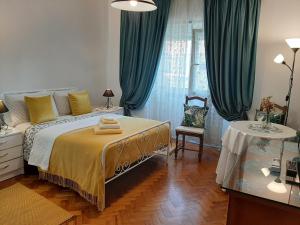 a bedroom with a large bed with green curtains at Mary Apartments in Almada