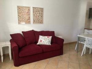 a red couch in a living room with a table at Almarea Corallo - villa a 300m dalla spiaggia con parcheggio - Polignano a Mare in Polignano a Mare