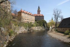 a river in front of a large building at Apartmány Záhořovo Lože in Horní Planá