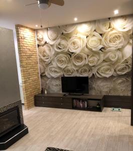 a living room with a wall with roses on it at Karlsons apartment in Liepāja
